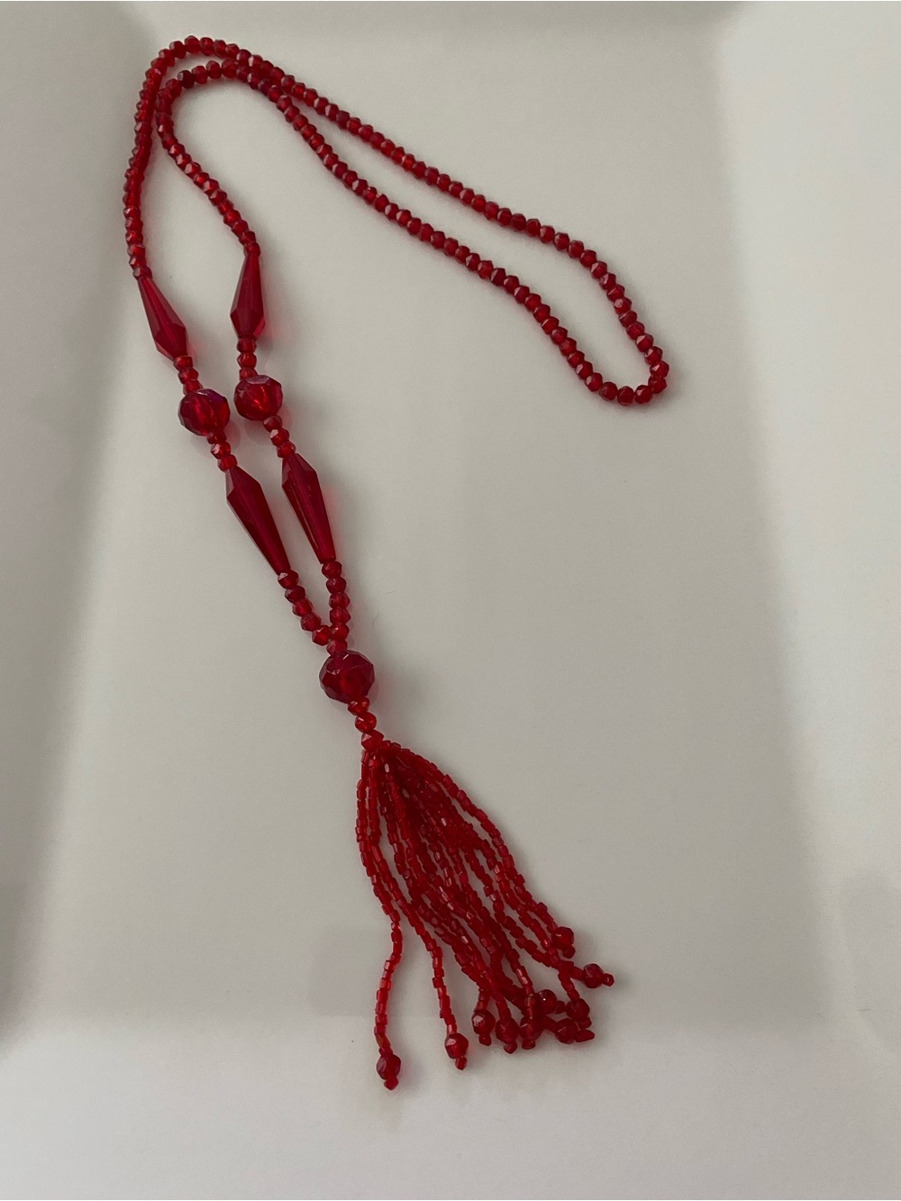 A vintage Art Deco red glass sautoir necklace with a tassel